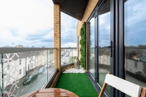 吉林汉姆Stay Solution - Comfort Guaranteed的阳台铺有绿色地板,设有大窗户。