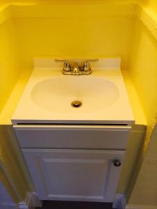 旧金山奥尔德里奇酒店的浴室水槽和黄色墙壁上的水龙头