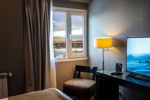 乌斯怀亚奥拓安迪诺酒店的酒店客房设有一张书桌、一台电视和一个窗户。