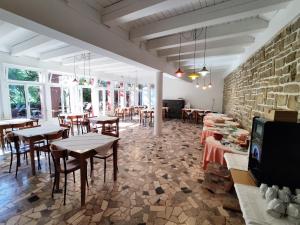 皮兰Morski gaj Resort的一间带桌椅的餐厅以及砖墙