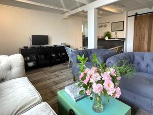 圣贾斯特Charming Studio in Heart of Vibrant St Just, West Cornwall的客厅,桌子上放着花瓶