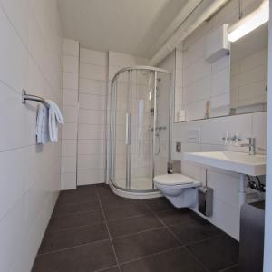 格伦兴Omnium Sport Hotel的带淋浴、卫生间和盥洗盆的浴室