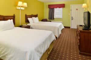 PrincetonAmerican Inn Princeton的酒店客房设有两张床和一台平面电视。