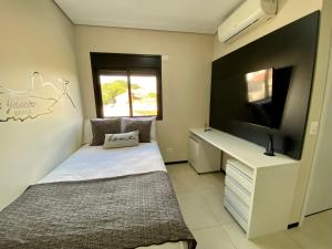 马里利亚32A Estudio perto do HC的一间卧室配有一张床、一张书桌和一台电视