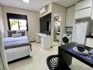 马里利亚32A Estudio perto do HC的一间卧室配有一张床,厨房配有桌子