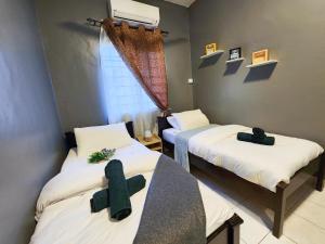 莎阿南Shah Alam U8 FULLY AIR-CON Suite的客房设有两张带十字架的床。