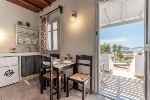 考弗尼西亚Michalios Luxury Apartments的厨房配有桌椅和窗户。