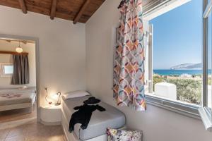 考弗尼西亚Michalios Luxury Apartments的一间卧室设有一张床和一个大窗户