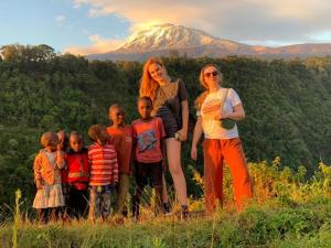 Kilimanjaro Mountain View Campsite的一群站在山前的儿童