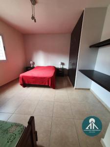 圣胡安Complejo Temporario Las Marias的一间在房间内配有红色床的卧室