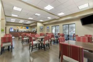圣安东尼奥圣安东尼奥机场康福特茵酒店的一间带桌椅和电视的用餐室