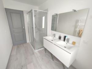 奥朗日Maison au calme avec parking proche centre-ville的白色的浴室设有水槽和淋浴。