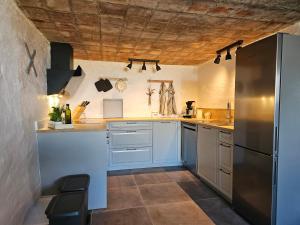 蒂霍尔姆B&B Hygge Jegindø的厨房配有白色橱柜和不锈钢冰箱