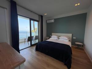 伯德古拉Beachfront Comfort Apartments SINAJKO的一间卧室设有一张大床和一个大窗户