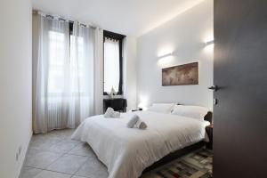 米兰PrimoPiano - Casoretto的一间白色卧室,配有两张床和窗户