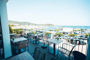 马奇纳奇奥滨海德奥罗酒店的阳台配有桌椅,享有码头的景致。