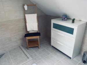 托考伊Megnyugtat-LAK Vendégház的一间带白色梳妆台和木椅的浴室
