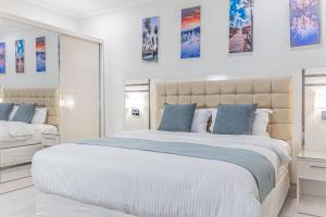 达曼Mooj Apartments Hotel- فندق موج للشقق الفندقية的白色卧室配有一张带蓝色枕头的大床
