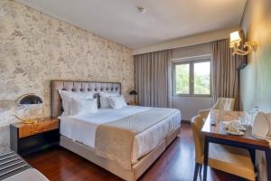 巴塔拉Hotel Lis Batalha的配有一张床和一张书桌的酒店客房