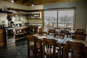 拉斯特朗卡斯富希奥艾克博克斯安迪诺度假屋的厨房配有木桌和椅子,设有大窗户