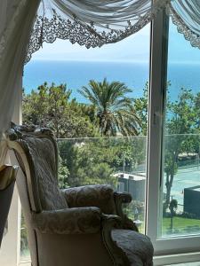 安塔利亚Konyaaltı plajına 10 dakika kral dairesi的靠窗前的椅子,靠在大海上