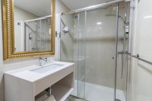 巴塔拉Hotel Lis Batalha的一间带水槽和玻璃淋浴的浴室
