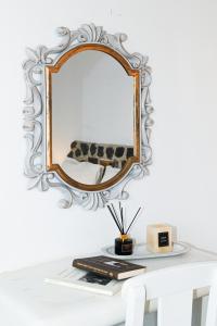 卡马利Villa Maina的桌子上墙上的镜子,带书