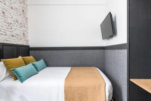 毕尔巴鄂BYPILLOW San Mamés的卧室配有一张床铺,墙上配有电视