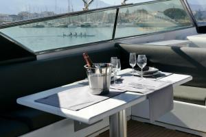 巴勒莫A bordo della Maeva Star的一张桌子,上面放有酒杯和船上的一瓶