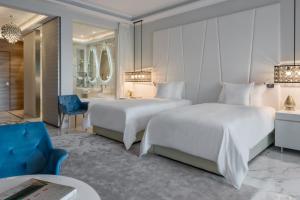 纳祖尔Marchica Lagoon Resort的酒店客房,设有两张床和一张蓝色椅子