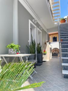 爱琴娜岛Aiginetan Apartments的天井上摆放着桌子和盆栽植物
