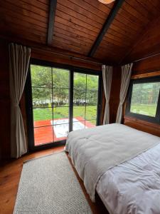 ArdeşenNoveli Tiny House的一间卧室设有一张床和大窗户