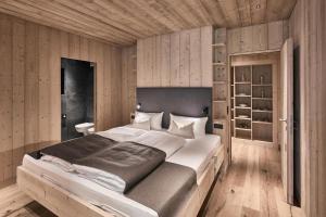 拉辛Tenne Chalet的一间卧室设有一张大床和木墙