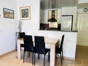 埃斯塔蒂特Brises del Mar 3-3的厨房配有木桌和黑色椅子