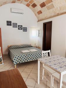 滨海波利尼亚诺Dimora dei Pellegrini 8的小房间设有一张床和一张桌子