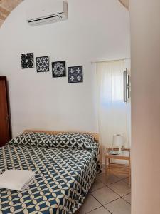 滨海波利尼亚诺Dimora dei Pellegrini 8的卧室配有一张床,墙上挂有图片