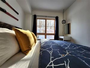 蒙特朗布朗EDM 1500-2/Your Mountain Oasis的一间卧室设有一张床和一个窗口
