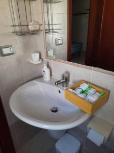 卡利亚里Stylish Loft Trivano Cagliari 2 beds/2 bath的浴室水槽和毛巾的木制托盘