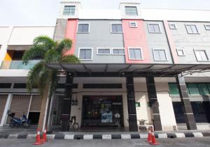 怡保Hotel Pulai Ipoh的商店前有棕榈树的建筑