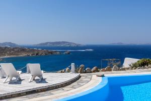 胡拉吉亚Seablue Villas的一个带椅子的游泳池,享有海景
