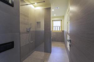 利维尼奥Arion Apartments - Trepalle的带淋浴的浴室和玻璃门