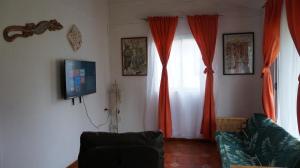 安加罗阿复活节岛露营度假屋的客厅配有橙色窗帘和沙发