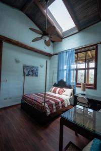 洛哈Vilcabamba casa / granja Vilcabamba house / farm的一间卧室配有一张床和吊扇