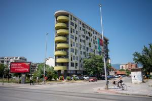 斯科普里Skopje Station Apartment的城市街道上的一座建筑,人们骑着自行车