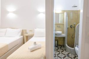 佩里萨费沃斯别墅酒店的配有2张床的客房设有淋浴和盥洗盆