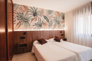 波多诺伏香克拉酒店的一间卧室配有一张床和壁画墙