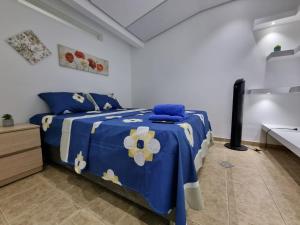 卡利Hospedaje Casa Leví的卧室配有蓝色和白色的床和水槽