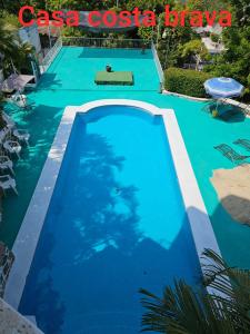 阿卡普尔科Casa Costa Brava的蓝色游泳池,上面标有读卡萨卡萨卡萨卡萨布拉瓦的标志