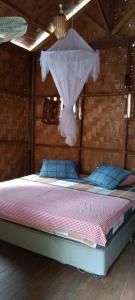 武吉拉旺Sumatra Jungle Trek In & Orangutan Trips的一间卧室配有一张带蚊帐的床