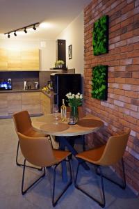 下乌斯奇基Apartament Mech & Paprocie的厨房里设有一张桌子和椅子,厨房里设有砖墙